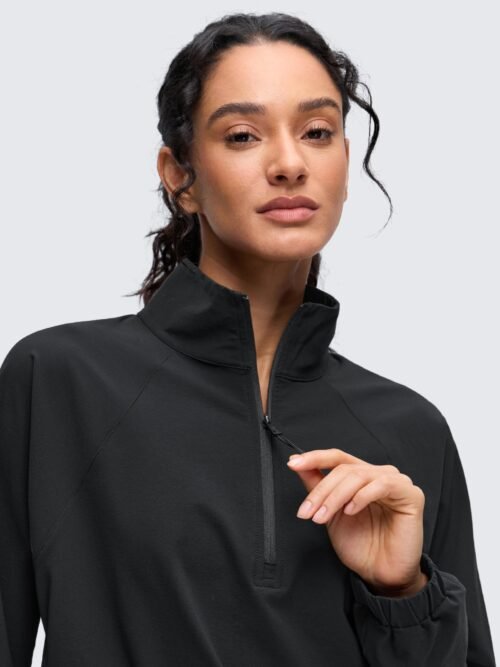 Women's black cropped half-zip jacket with stand collar, drawstring hem, elastic cuffs, and front pockets for yoga and outdoor activities