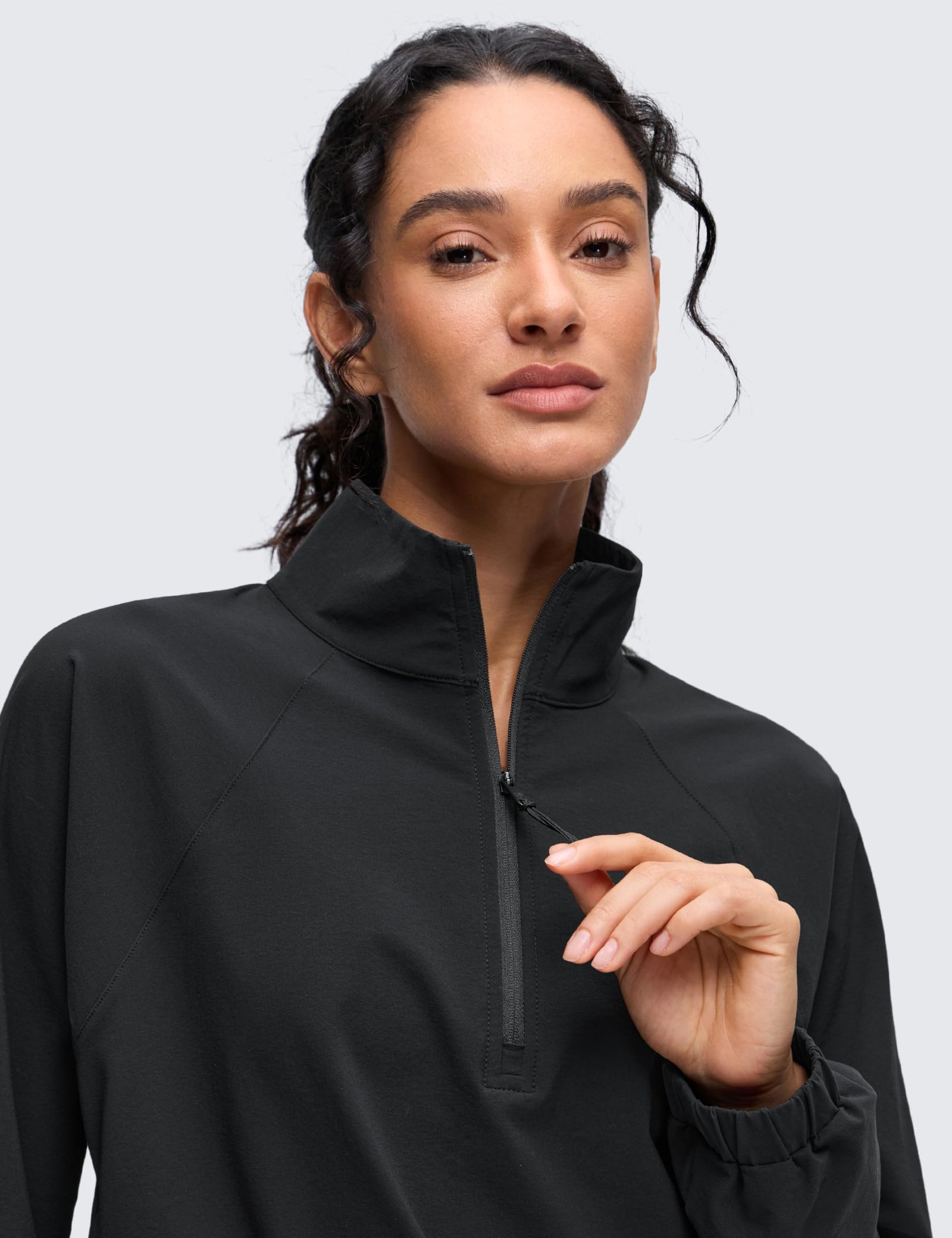 Women's black cropped half-zip jacket with stand collar, drawstring hem, elastic cuffs, and front pockets for yoga and outdoor activities