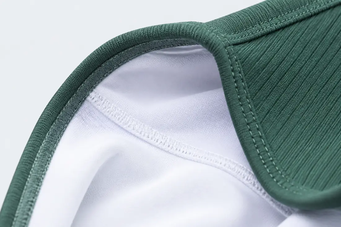 Macro close up of custom swimwear manufacturer craftsmanship showing double layer lining and chlorine resistant elastic binding