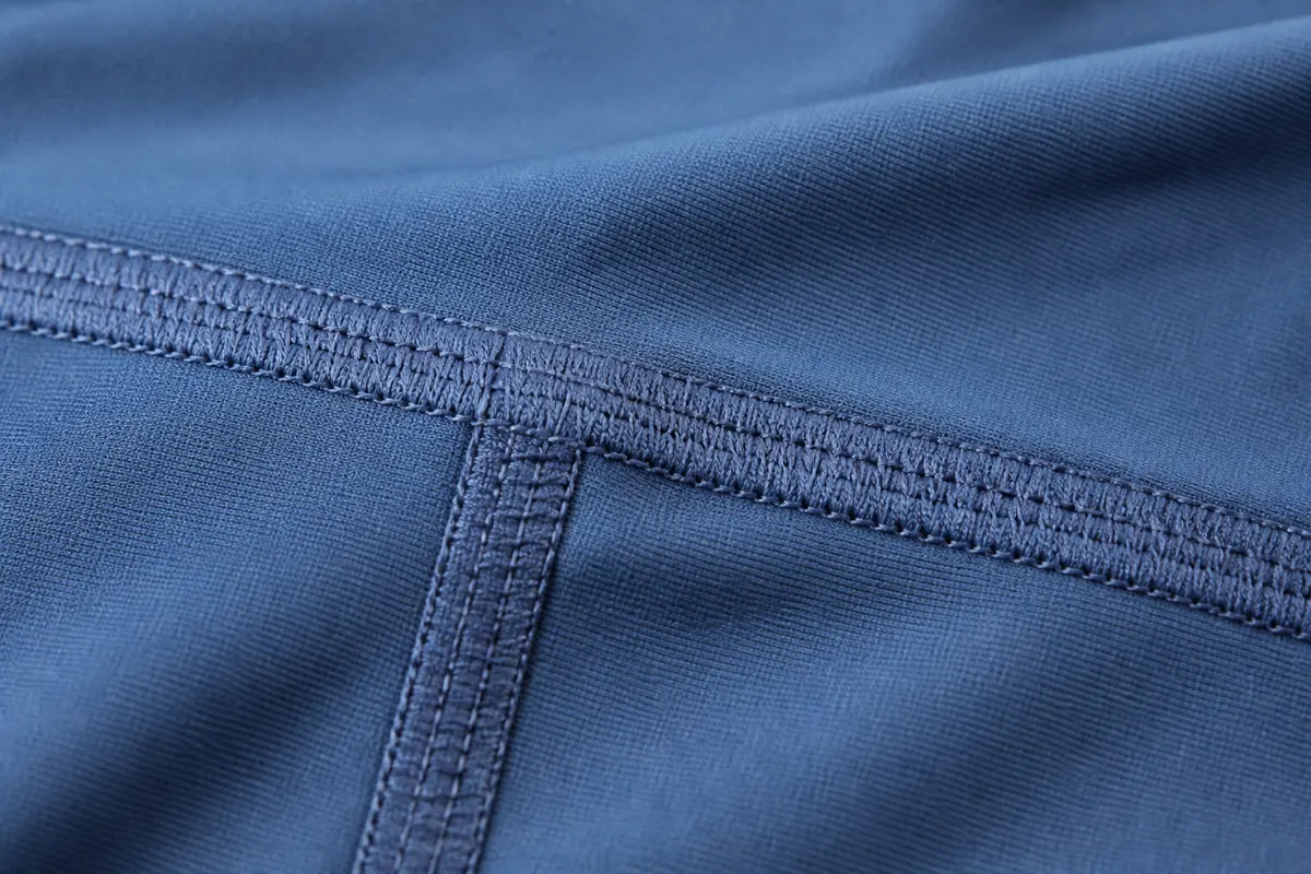 Macro close up of 4-needle 6-thread flatlock stitching on custom yoga leggings manufacturing